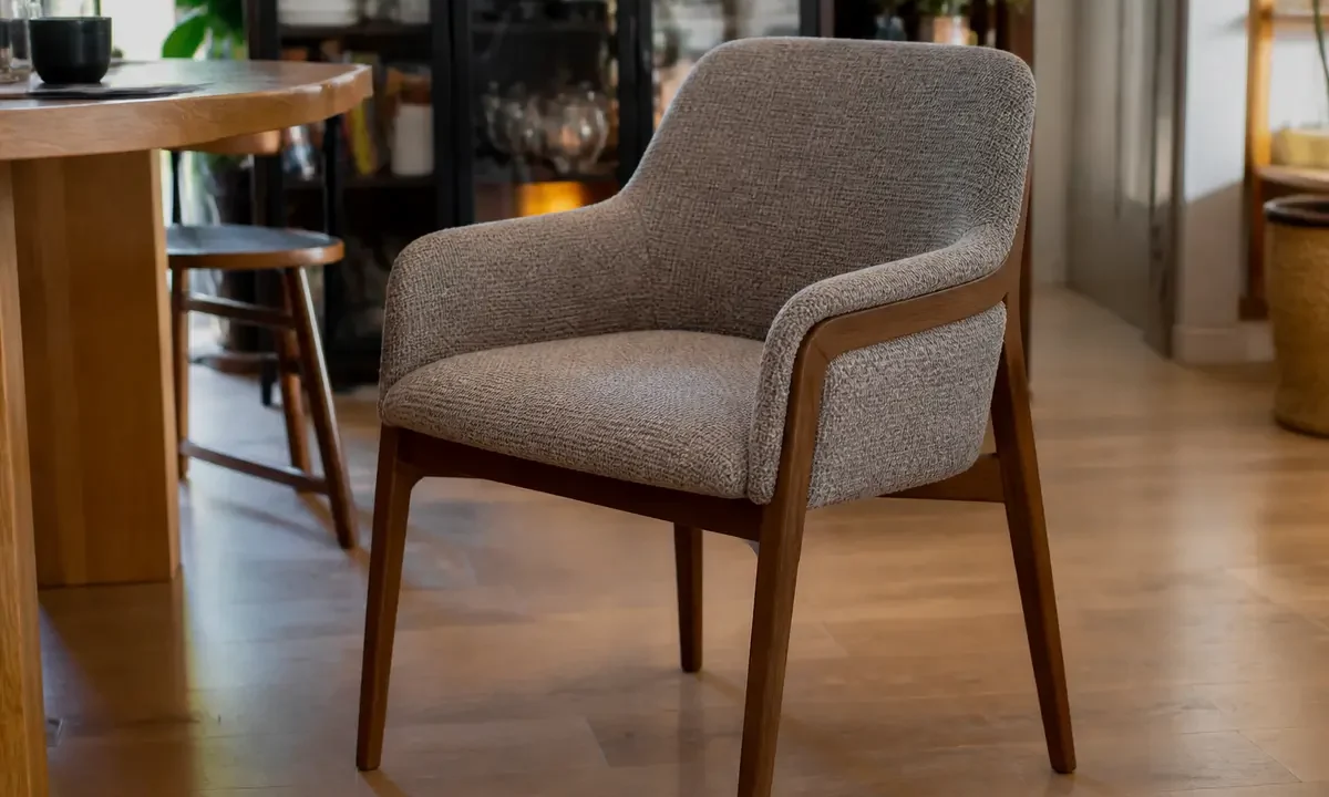 Chaise avec accoudoirs élégante en bois et tissu dans une salle à manger chaleureuse
