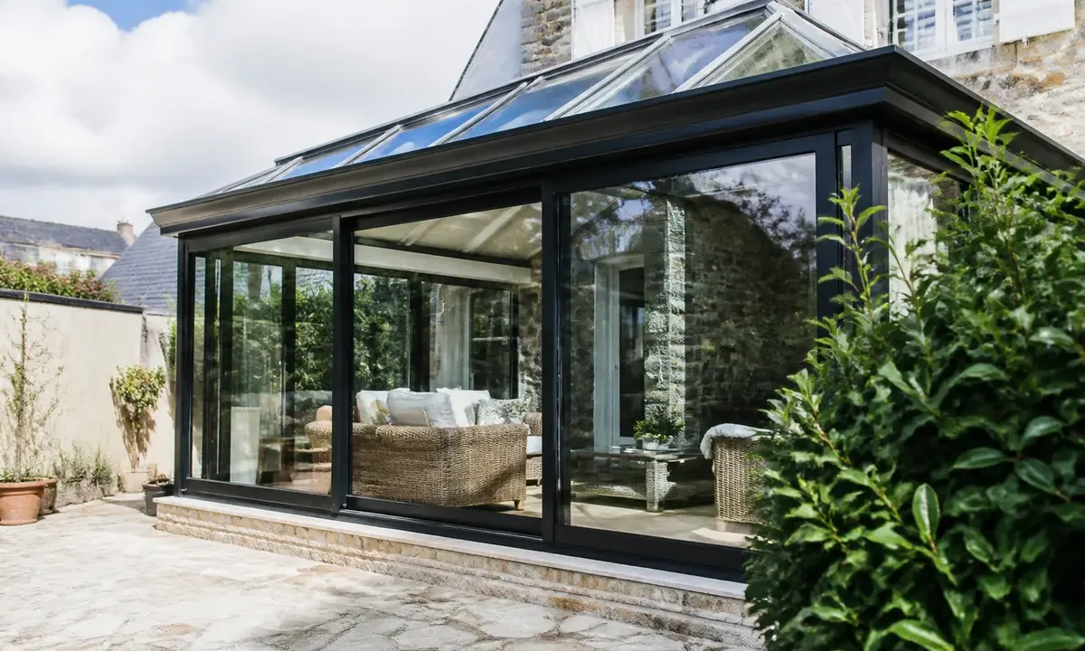 Véranda moderne avec mobilier en rotin et discussions sur le prix au m2 estimé